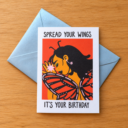 Spread Your Wings greeting card by Lo Harris, styled on a table
